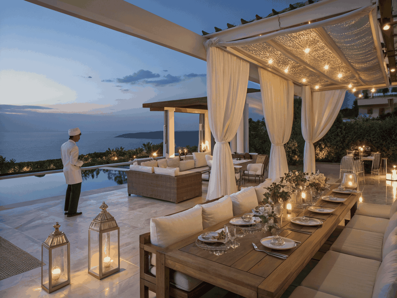Private estate courtyard at dusk with warm amber lighting and a serene, exclusive coastal atmosphere